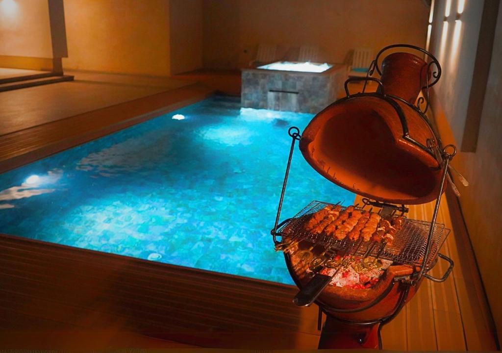 a swimming pool with a grill in the middle of it at Villa Sable de Mirleft Luxury Apartment in Mirleft