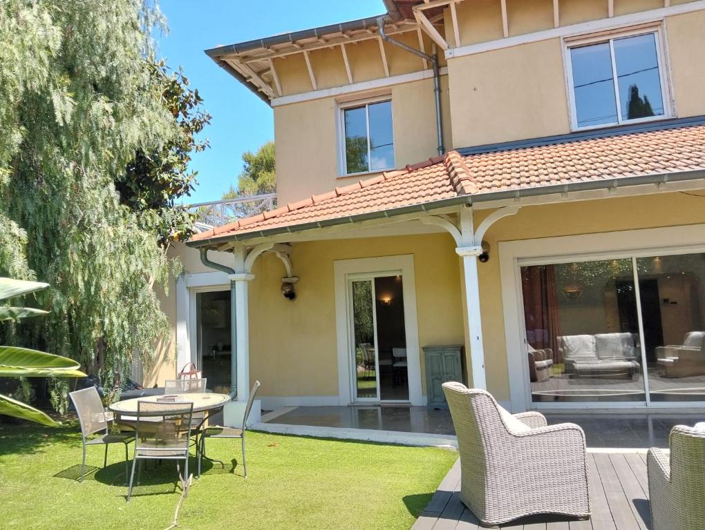 een huis met een patio en een tafel en stoelen bij Villa HELIOS in Cannes