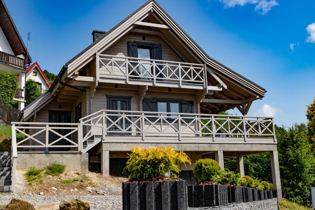 a wooden house with a large balcony at Jutrzenka in Międzybrodzie Kobiernickie