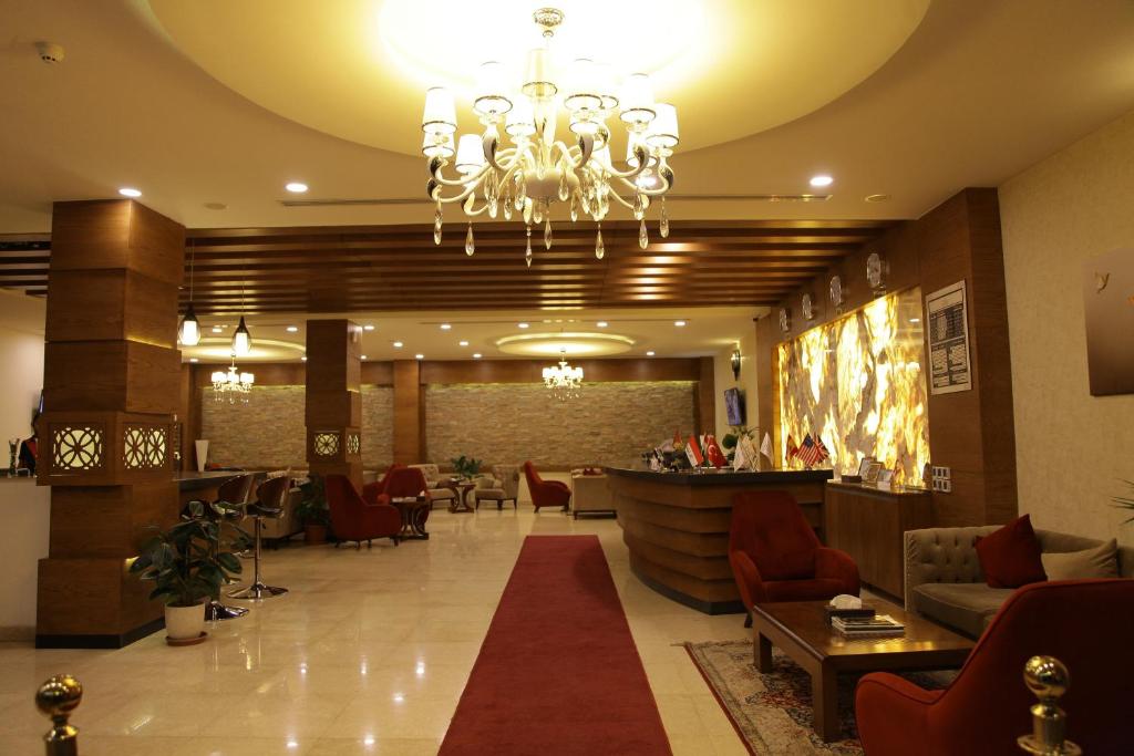a lobby of a hotel with a chandelier at Quaint Hotel Erbil in Erbil