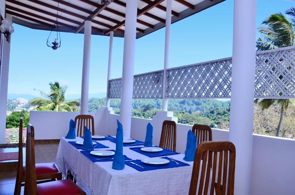 uma sala de jantar com mesa e cadeiras em Kandyan White Holiday Homes em Kandy