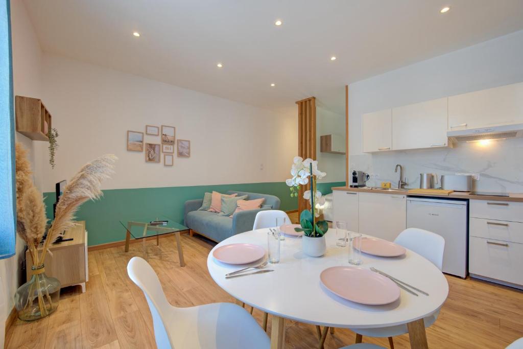 a kitchen and a living room with a table and chairs at Le Grain De Folie / Place Des Halles in Tours