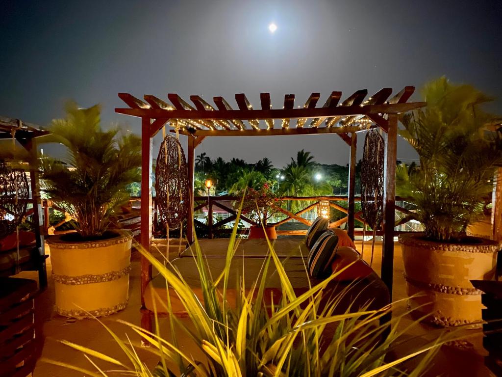 a pergola with plants in pots on a patio at Hotel Para Ti - Adults Only in Holbox Island