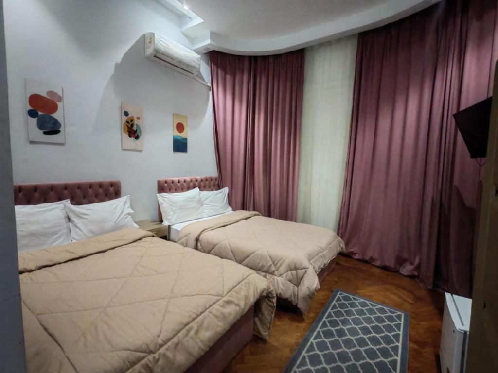 a hotel room with two beds and curtains at Centro Citta Hotel in Cairo