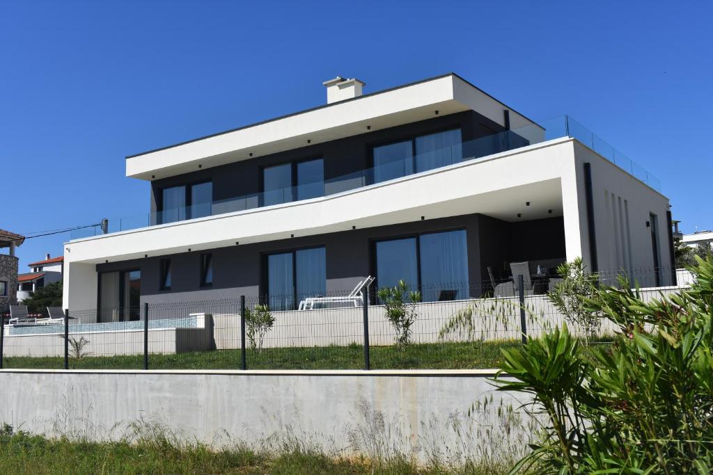 a house with black and white at Villa M&M in Ližnjan