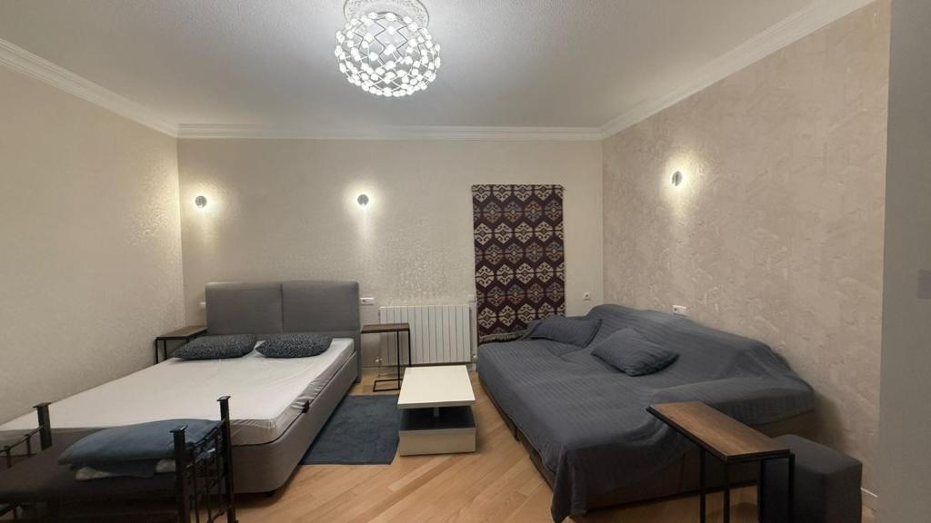 ein Schlafzimmer mit zwei Betten und einem Kronleuchter in der Unterkunft Guest House at Old Tbilisi in Itʼkhvisi