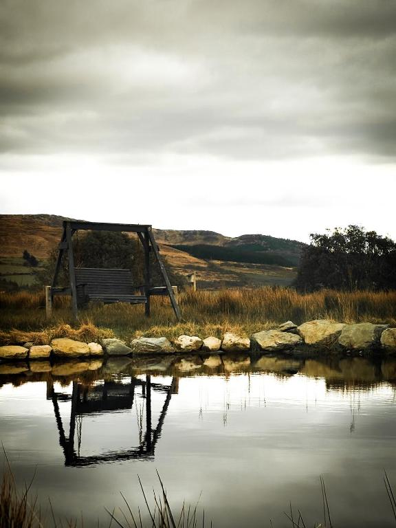 a bench sitting next to a body of water at Wild Hideaways Luxury Lodges and Eco Spa in Bantry
