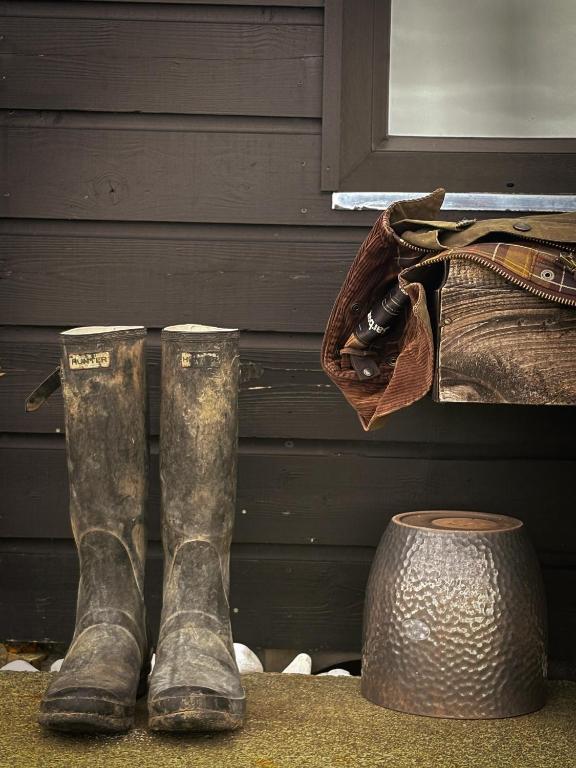 a pair of muddy boots next to a bag at Wild Hideaways Luxury Lodges and Eco Spa in Bantry