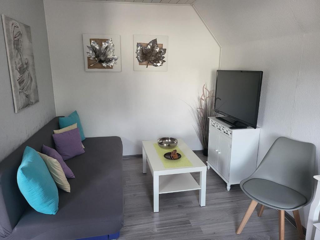 un piccolo soggiorno con divano e TV di Ferienwohnung Altmann a Prerow