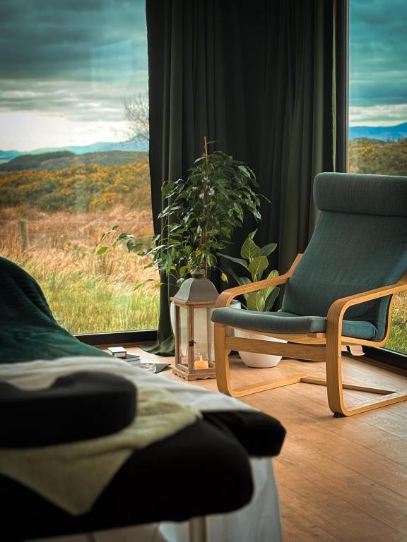 a room with a chair and a window with a view at Wild Hideaways Luxury Lodges and Eco Spa in Bantry