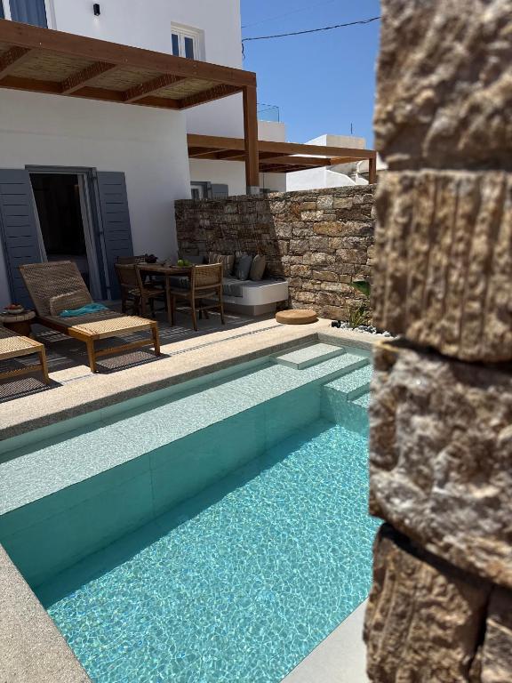 a swimming pool in front of a house at Ios Art Suites in Ios Chora