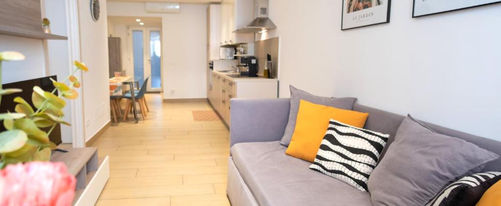 a living room with a gray couch and yellow pillows at Luna Luxury Suite in Bergamo