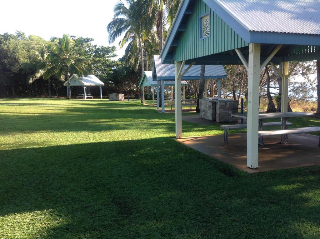 a grassy area with a bench and some trees at Tannum Sands Hotel / Motel in Tannum Sands