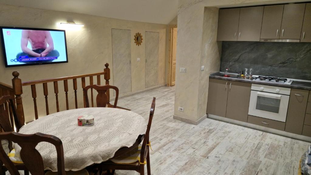 Una cocina con una mesa y un televisor en la pared. en Ela house, en Brasov