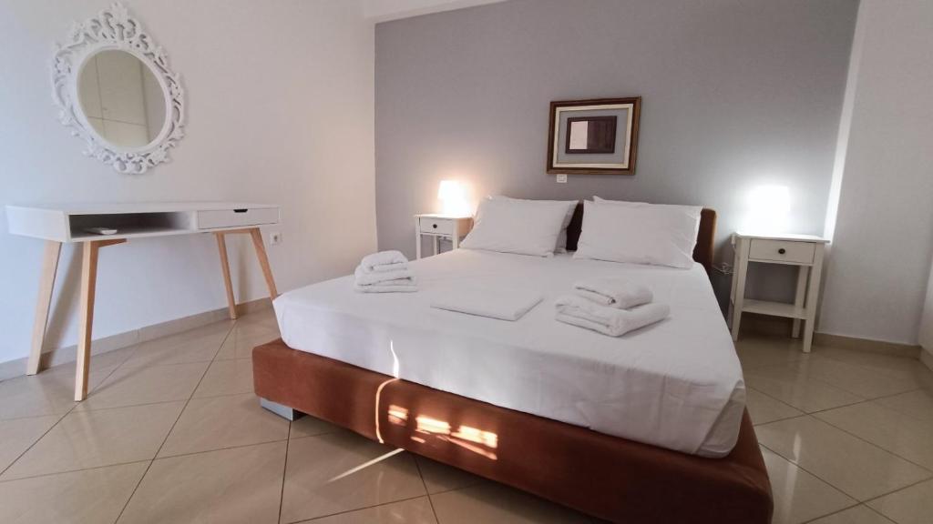 a bedroom with a large bed with towels on it at Tenios Urban nest retreat in Kalamata