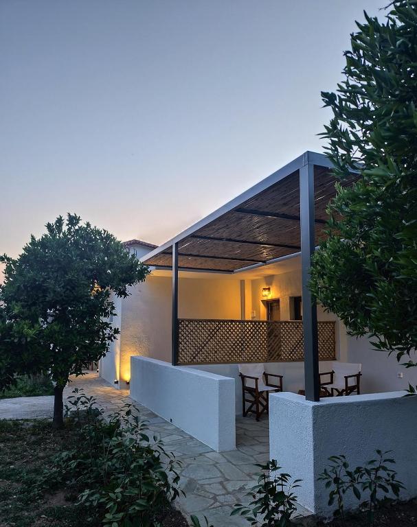 a home with a patio with a table and trees at Kaia Studios Agnondas in Agnontas