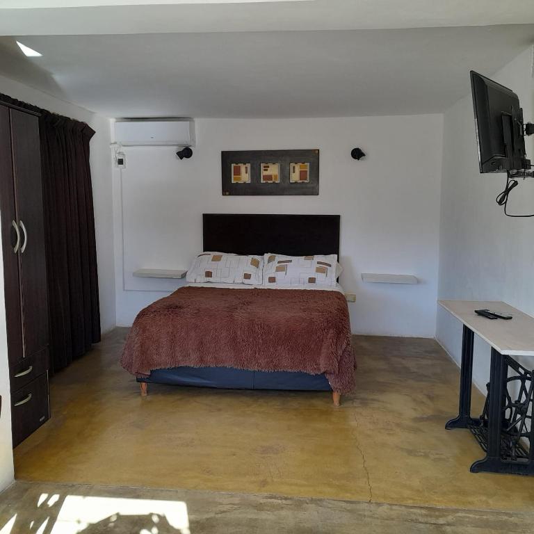a bedroom with a bed and a desk and a television at Bella Vista in Valle Hermoso