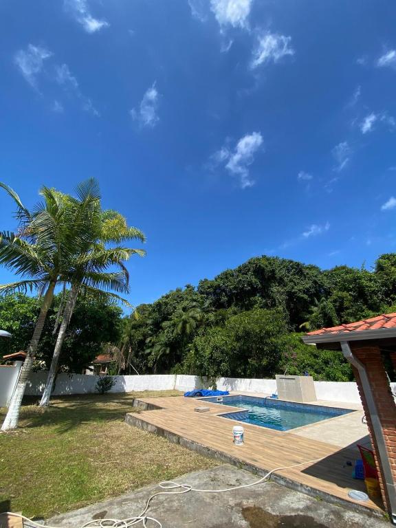 a backyard with a pool and a palm tree at Seu Cantinho de Paz em Iguape in Iguape