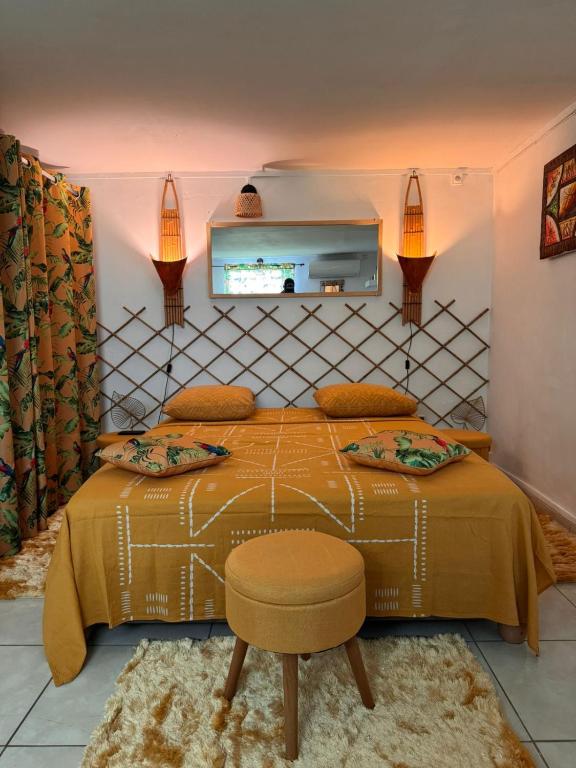 a bedroom with a bed and a tv on the wall at La Kaza Tresor - Appartement T2 spacieux avec jacuzzi privé in Sainte-Anne