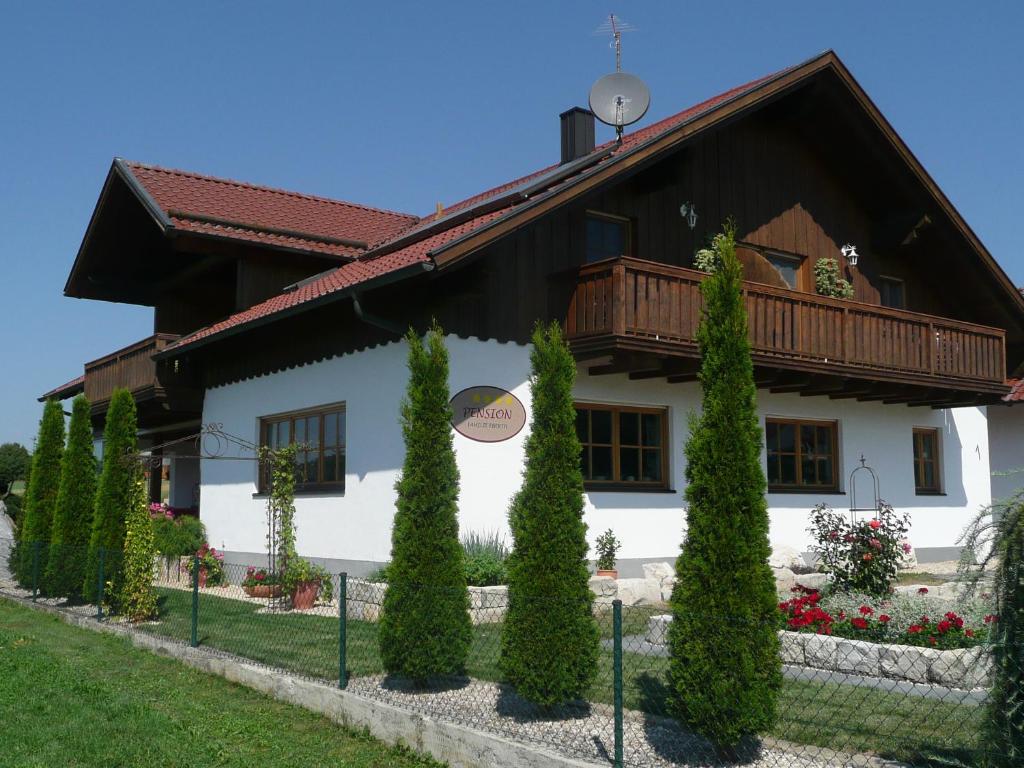 a white house with a wooden roof at Privatpension Eberth in Bogen