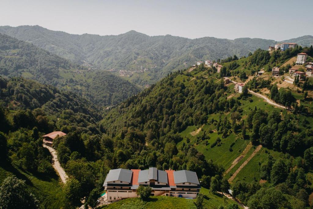 a house on top of a hill with mountains at Yege Villa Bungalov in Çamlıhemşin