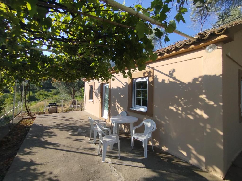 a table and chairs in the shade of a building at Olive House in Petrovac na Moru