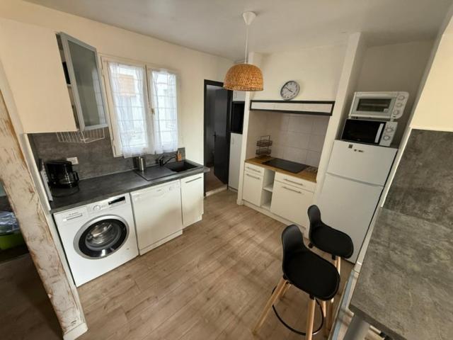 une cuisine avec un lave-linge et deux chaises dans l'établissement Appartement centre-ville Narbonne 5 personnes, climatisé, 2 chambres, à Narbonne