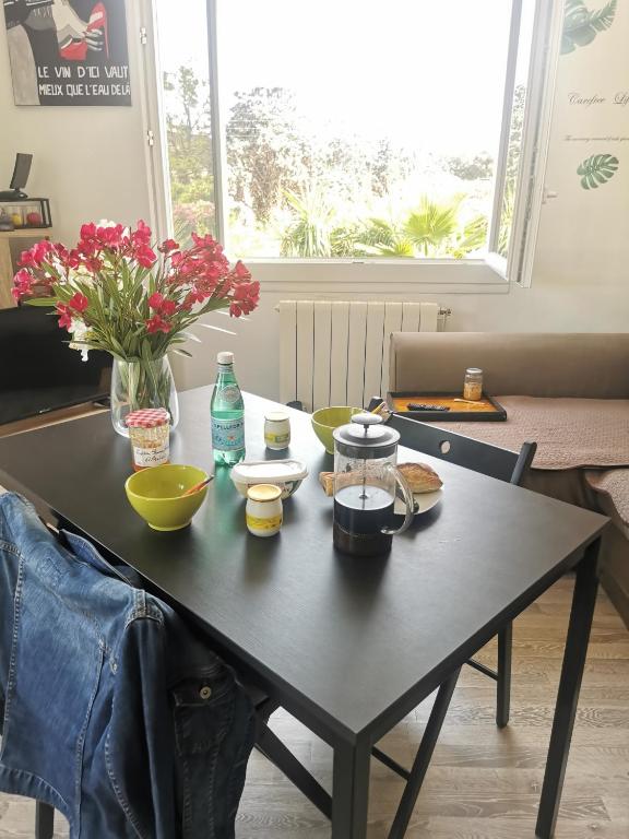 une table noire avec des plats et des fleurs dessus dans l'établissement Entre montagne et mer, à La Valette-du-Var
