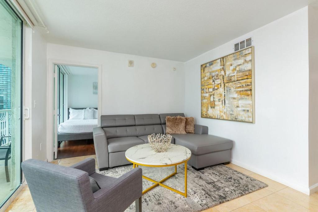 ein Wohnzimmer mit Couch und Tisch in der Unterkunft 3 bedroom stunning apt brickell in Miami