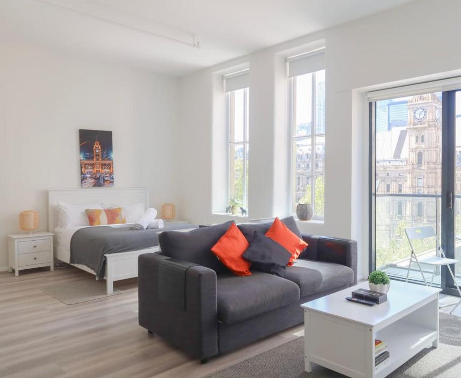 a living room with a couch and a bed at The Clocktower Light and Airy Studio on Bourke St in Melbourne