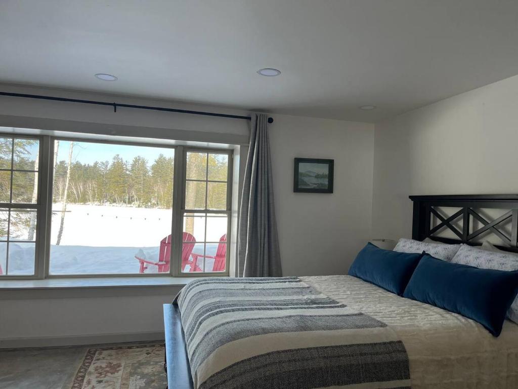 a bedroom with a bed and a large window at Wolf Pond 1 - 3 Miles to Lake Placid NY in Lake Placid