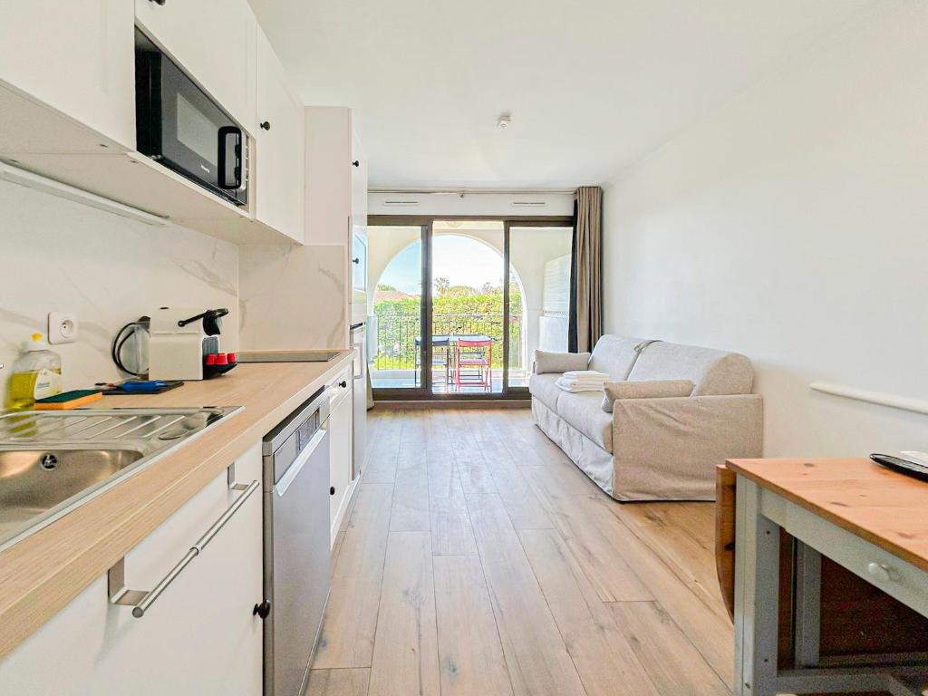 une cuisine et un salon avec un canapé dans l'établissement Élégance Azuréenne - piscine et parking, à Villefranche-sur-Mer
