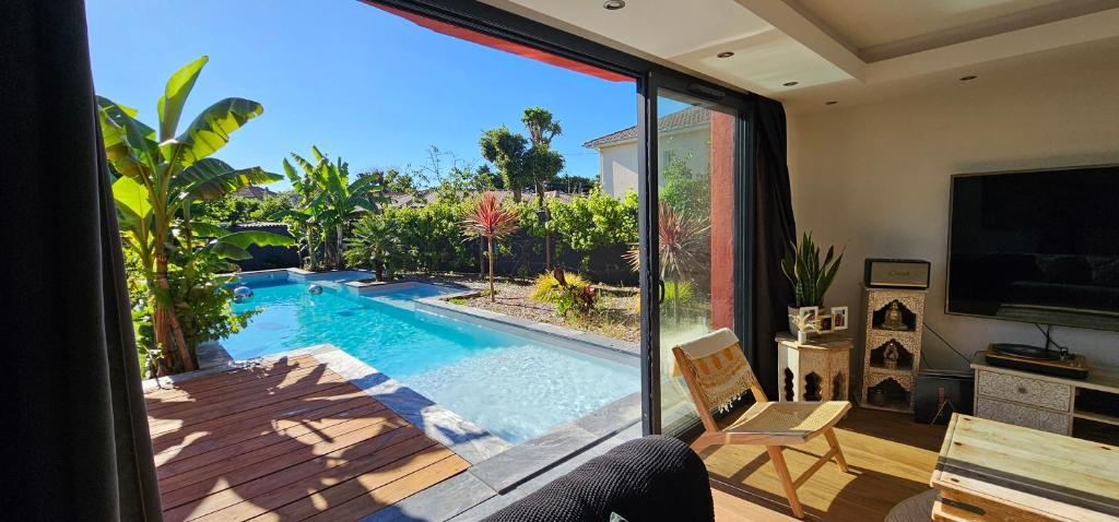 - un salon avec vue sur la piscine dans l'établissement Villa Pessac jardin luxuriant et piscine chauffée, à Pessac