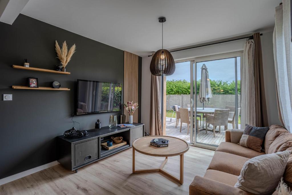 un salon avec un canapé et une table dans l'établissement la maison du bord de mer, à Penvénan
