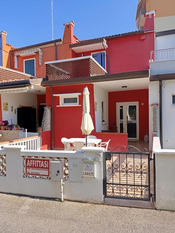 a building with a table and an umbrella in front of it at La Casa dei Pescatori in Caorle
