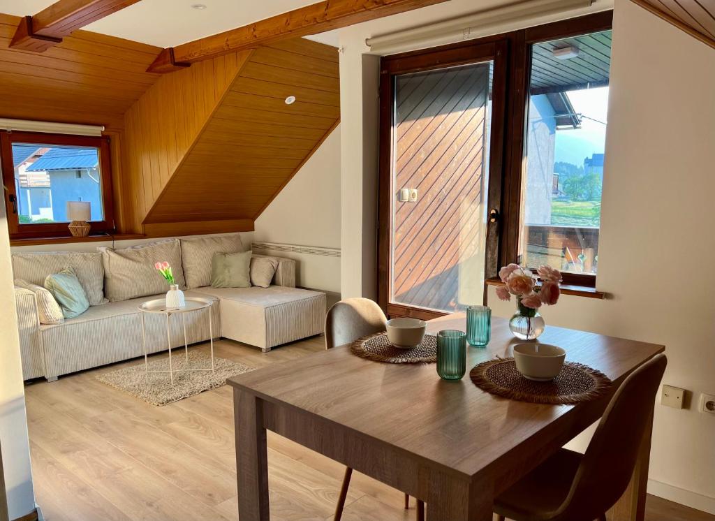 un soggiorno con un tavolo e un divano di Studio Lilly a Bohinj