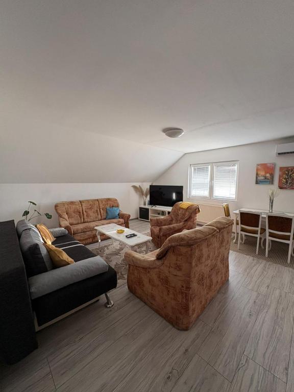 a living room with two couches and a table at Apartman Salus in Tuzla