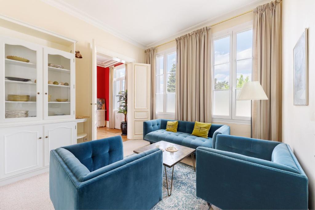 un salon avec des chaises bleues et une table dans l'établissement Les maisons d'Emilion, à Vignonet