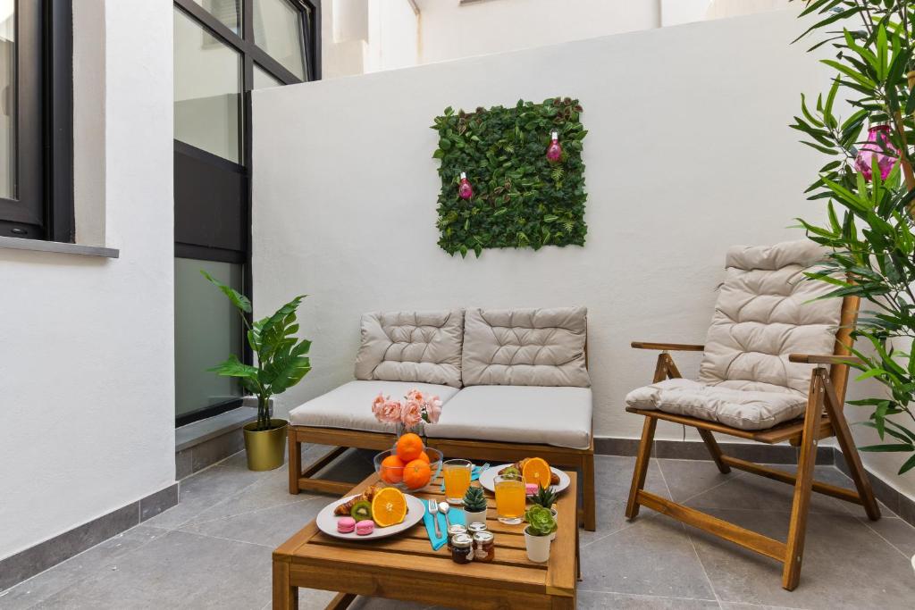 a patio with a couch and a table with food on it at Urban Oasis in Fuengirola