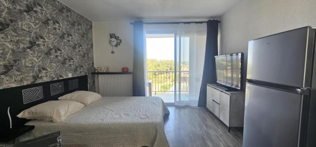 une chambre avec un lit et une télévision dans l'établissement La Dolce Vita, à Balaruc-les-Bains