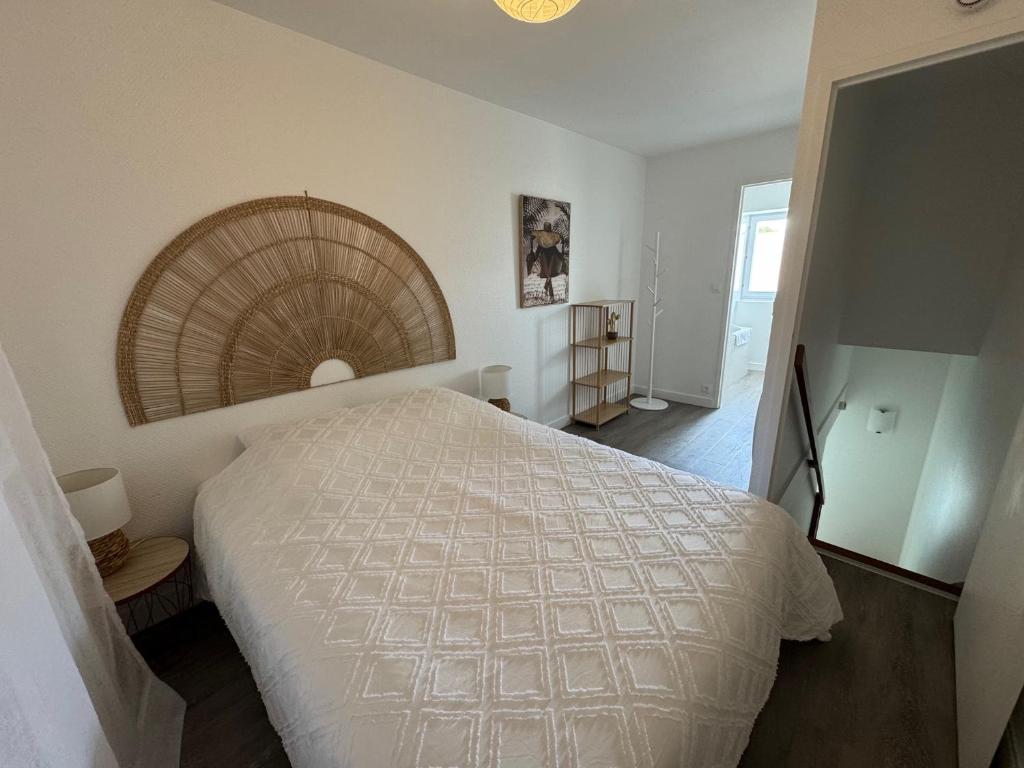 Un dormitorio con una gran cama blanca en una habitación. en Logement proche Aéroport Nantes, en Saint-Aignan-Grand-Lieu