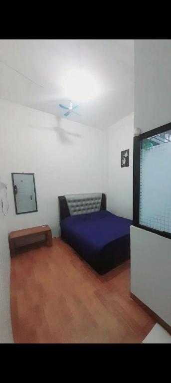 a room with a blue bed and a tv at Nafisha Hotel Bukittinggi in Bukittinggi