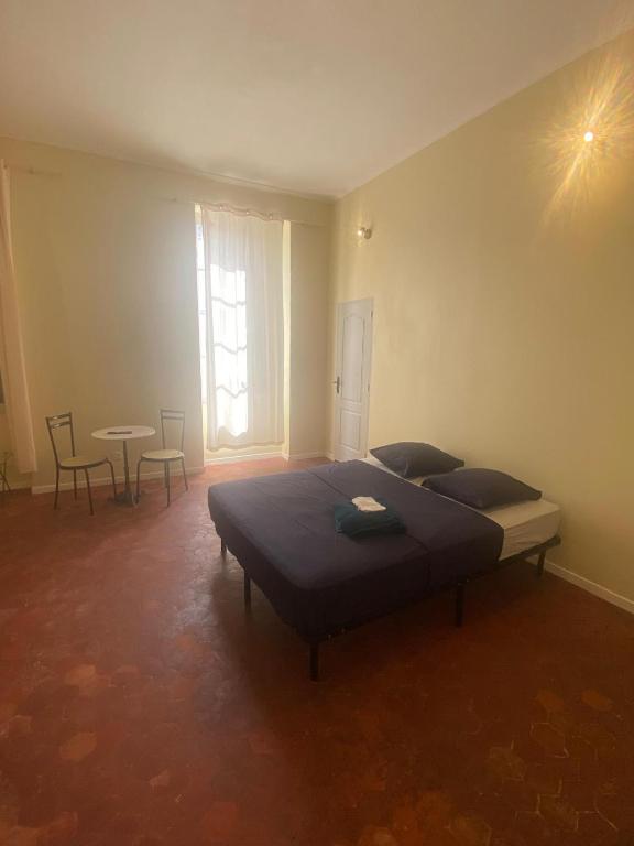 une chambre avec un lit, une table et des chaises dans l'établissement Centre Roquemaure, à Roquemaure