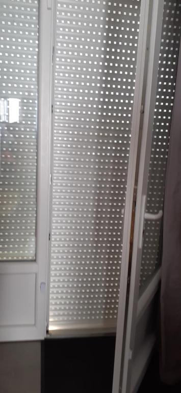 La salle de bains est pourvue d'une porte en verre et d'une fenêtre. dans l'établissement Chambre 21m2, à Sigean