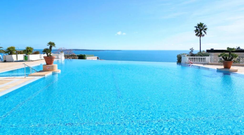 - une piscine d'eau bleue dans un complexe dans l'établissement Villa Francia 2P with splendid pool -private rental, à Cannes