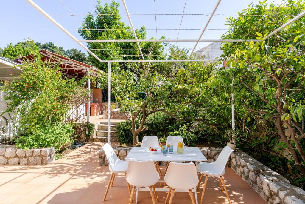a table and chairs in the garden of a house at Holiday Home Mareta in Dubrovnik