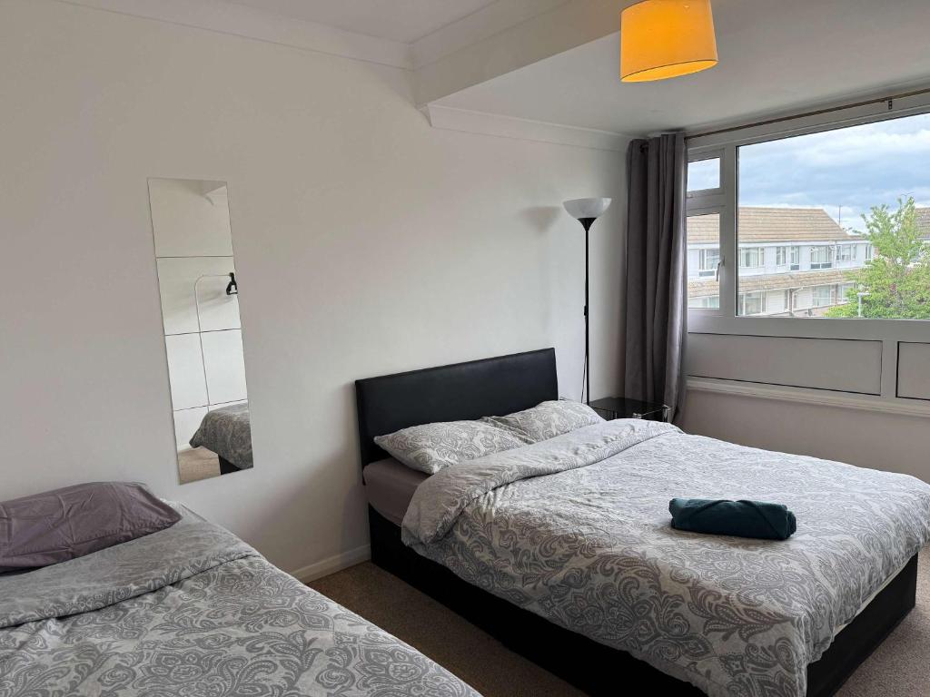 a bedroom with two beds and a large window at Chelmsford 3 Bedroom Accommodation with parking in Chelmsford