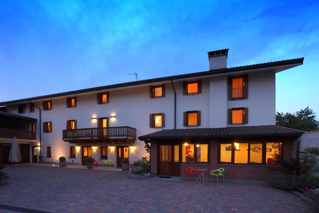 Un grand bâtiment blanc avec de nombreuses fenêtres dans l'établissement Agriturismo Tonutti, à Tavagnacco