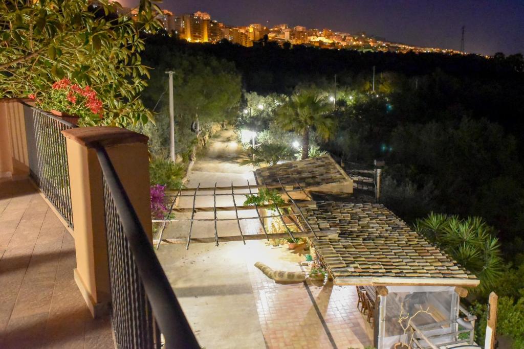 un grupo de mesas de picnic en un balcón por la noche en Parco dei Templi, en Agrigento