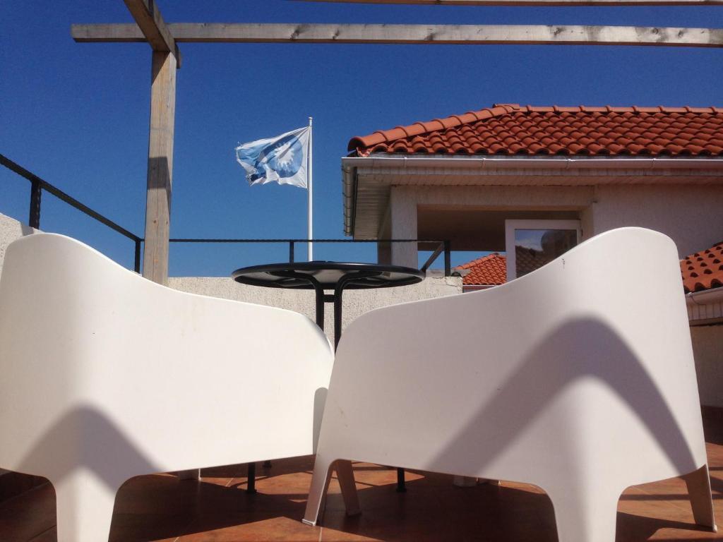 un par de sillas blancas y una bandera en un patio en OZ Vama Veche, en Vama Veche